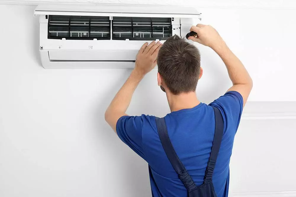 A technician fixing an air conditioning system